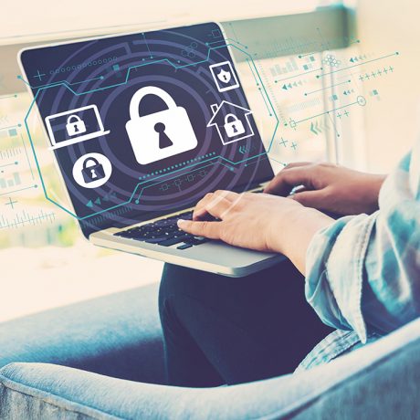 Security,Theme,With,Woman,Using,Her,Laptop,In,Her,Home Person using a laptop with a lock symbol to represent digital security
