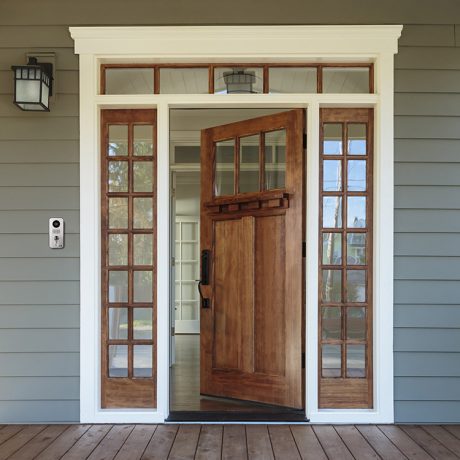 Doorbird Video Doorbell with Open Door Letting Out Smart Home Heating and Cooling in a connected home Wooden door with silver Doorbird video doorbell on left side of porch