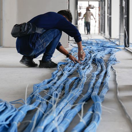 Worker,Wiring,Lan,Cable,At,Construction,Site.,Unfinished,Installation,Network Worker wiring LAN cable at construction site. Unfinished Installation network system.